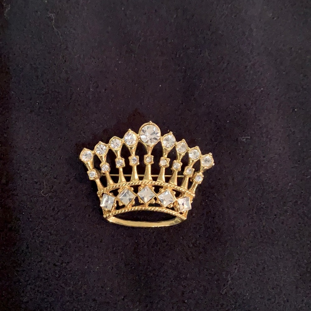 Costume gold colored crown w/ rhinestones pin. Good condition.